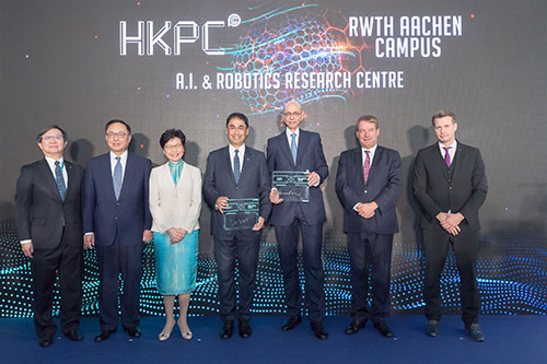 Mr Mohamed D. Butt, Executive Director of HKPC (centre), and Dr Claus Peter Groos, Managing Director of RWTH Aachen Campus GmbH (third from right), sign the Memorandum of Understanding to establish A.I. and Robotics Research Centre in Hong Kong, witnessed by Mrs Carrie Lam, Chief Executive of the HKSAR (third from left); Mr Dieter Lamlé, the German Consul General to Hong Kong and Macao (second from right); Mr Nicholas Yang, Secretary for Innovation and Technology of the HKSAR Government (second from right); Mr Willy Lin, Chairman of HKPC (first from left), and Mr Toni Drescher, Head of Technology Management of Fraunhofer IPT.