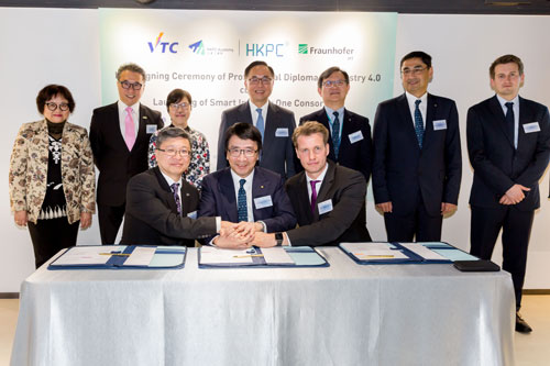 Witnessed by Mr Nicholas Yang, Secretary for Innovation and Technology of the HKSAR Government (back row, centre); Ms Annie Choi, Commissioner for Innovation and Technology (back row, third left); Mr Willy Lin, Chairman of HKPC (back row, third right); Professor Eric Yim, Deputy Chairman of VTC (back row, second left); Mr Mohamed D. Butt, Executive Director of HKPC (back row, second right); Mrs Carrie Yau, Executive Director of VTC (back row, first left); and Mr Benny Drescher, Head of Invention Center of Hong Kong (back row, first right); Dr Lawrence Cheung, Director (Technology Development) of HKPC (front row, centre); Dr Eric Liu, Deputy Executive Director of VTC (front row, left); and Mr Toni Drescher, Head of Technology Management of Fraunhofer IPT (front row, right), sign the MoU for Hong Kong’s first Professional Diploma Programme in Industry 4.0