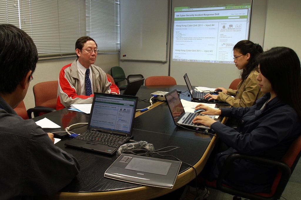 Mr Roy Ko, Principal Consultant (IT Industry Development) of HKPC and Manager of HKCERT, (second from left) monitors the drill at the command centre with representatives of the Office of the Government Chief Information Officer