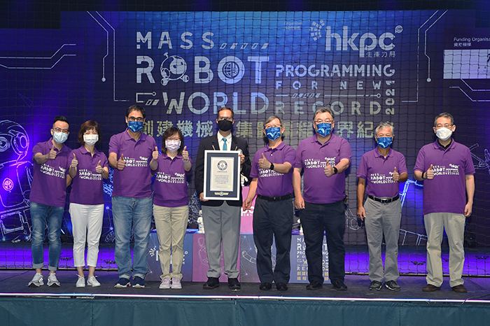 Ms Rebecca Pun, Commissioner for Innovation and Technology (fourth from left), and the HKPC team posed for a group photo with the representative of the Guinness World Records after successfully setting the world record on mass robot programming.