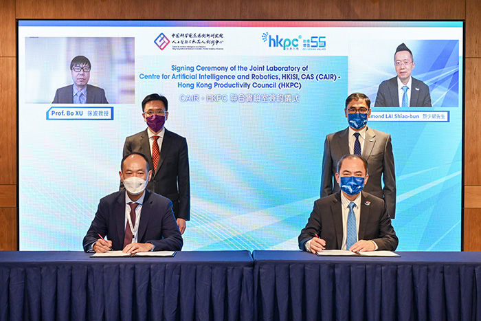 Witnessed by Dr Bo XU, Director of CAIR and President of Institute of Automation, Chinese Academy of Sciences (left, back row), Prof. Dong SUN, Secretary for Innovation, Technology and Industry, HKSAR Government (left, middle row); Mr Edmond LAI, Chief Digital Officer of HKPC (right, back row) and Mr Mohamed BUTT, Executive Director of HKPC (right, middle row), Dr Hongbin LIU, Executive Director of CAIR (seated left) and Dr Ming GE, General Manager of Robotics and Artificial Intelligence Division of HKPC (seated right) sign the CAIR-HKPC Joint Lab agreement. 